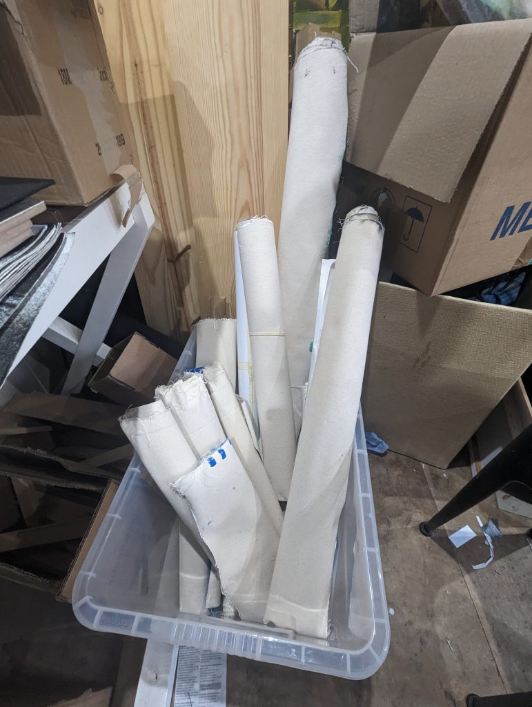 Canvasses rolled up and piled in a box